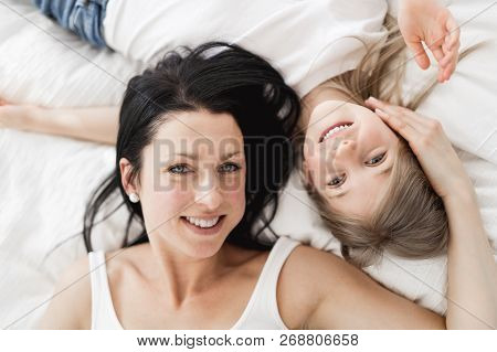 Mother And Daughter Enjoy In Bed At Home