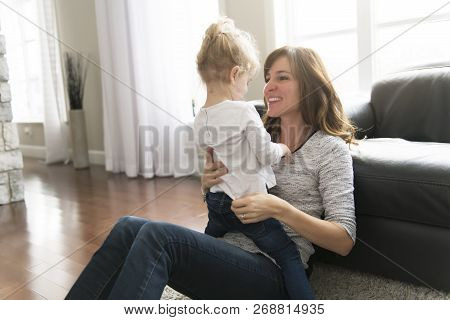 Happy Mother With Her Baby Daughter In The Living Room At Home