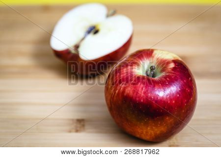 Red Apple Next To Slices Of Another Apple.