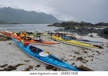 Several Colorful Kayaks Pulled Up On A Beach With A Squall Approaching Over The Mountains, Nuchatlit