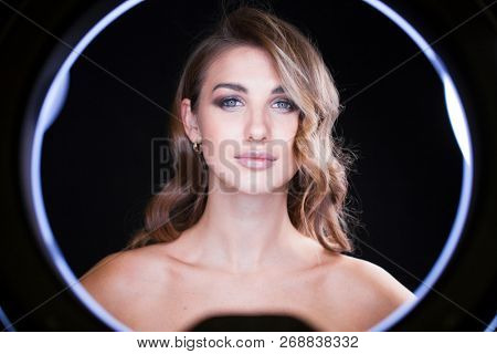 Studio portrait young woman in blue dress with ring flash effect. Round LED Circle Lamp