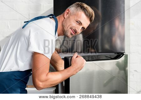 Adult Man Opening Shiny Silver Fridge Door