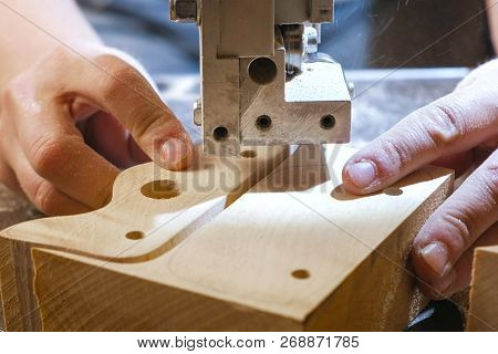 Craftswoman Is Cutting A Wood Workpiece From Wood With Bandsaw. Close-up Hands.
