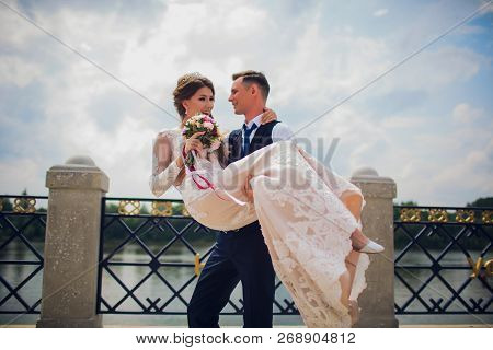 Stylish Bride And Groom Posing On The Background Of The River.