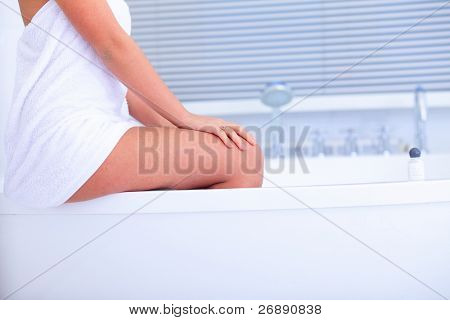 Joven hermosa mujer asiática sentada en el cuarto de baño moderno con jakuzzi