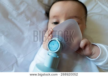 Baby In An Oxygen Mask. Child Inhalation. Selective Focus On The Mask. Closeup With Copy Space.