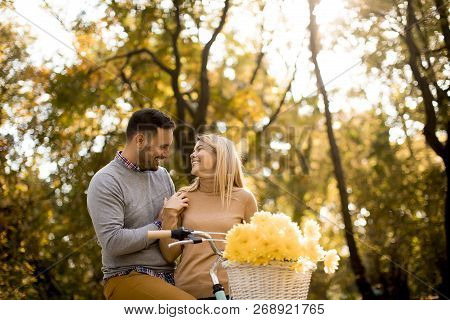 Active Young Couple Enjoying Romantic Walk With Bicycle In Golden Autumn Park