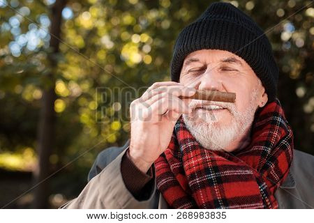 Joyful Nice Man Enjoying The Smell Of Cigar