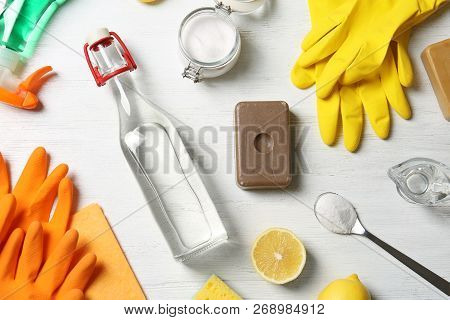Flat Lay Composition With Vinegar And Cleaning Supplies On White Wooden Background