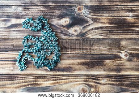Ire Burnt Wood Background. On It Lies A Metal Chain. Copy Space.