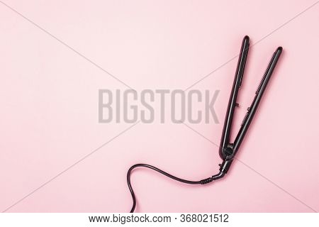 Hair Straightener On A Pink Background. Concept Of Hair Care, Hairstyle, Beauty Salon, Hairdresser. 