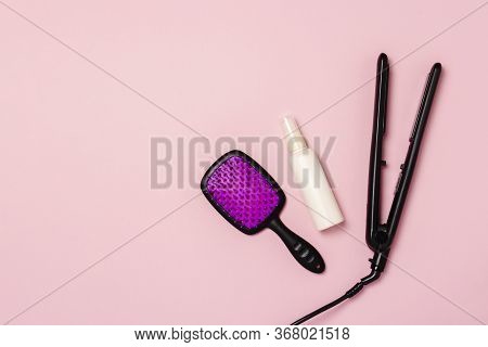 Hair Straightener, Comb And Hair Care Product On A Pink Background. Concept Of Hair Care, Hairstyle,