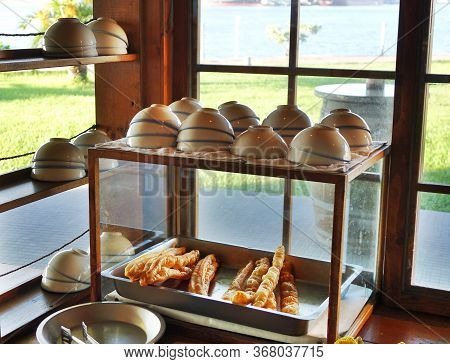 A Stall Sells Chinese Fried Breadsticks And Bowls Of Soybean Milk