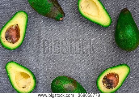 Opened Avocado Showing Seed On Textured Grey Linel Background. Top View, Copy Space, Organic Healthy