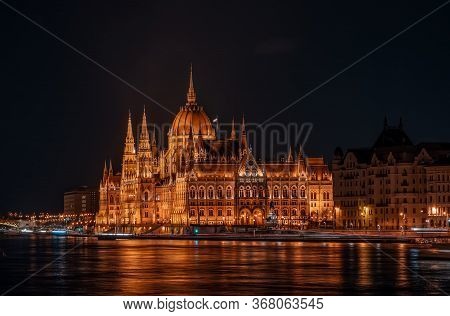 Long Exposure View Of Hungarian Paliament National Assembly By Danube River In The Evening