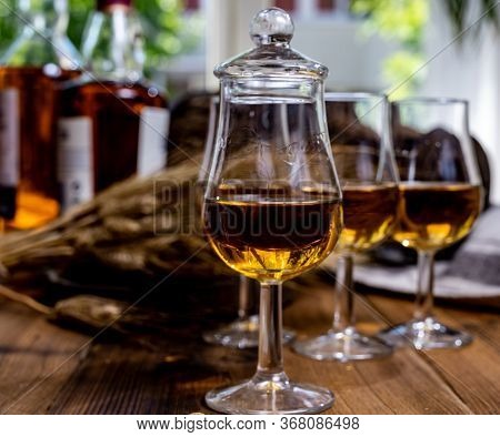 Tasting Glasses With Aged Scotch Whisky Or American Bourbon On Old Dark Wooden Vintage Table With Ba
