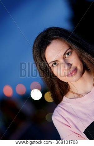 Portrait Of Pretty Smiling Girl In Pink Blouse In Evenig In Park