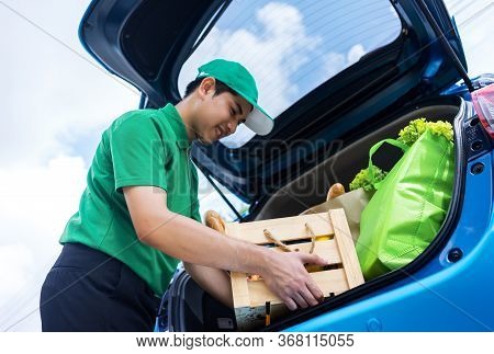 Asian Delivery Man In Green T-shirt Delivering Food, Fruit, Joice And Vegetable To Home - Online Gro