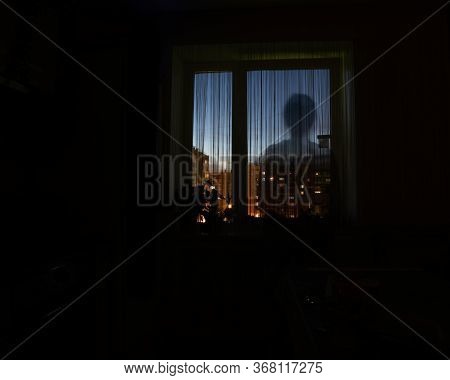 Shadow Silhouette Of A Man In The Night Window, Dark Background, Copy Space. The Idea Of Danger, Lon