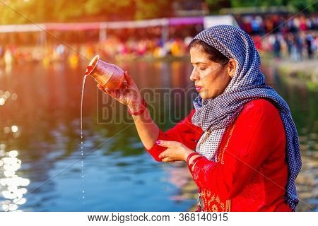 Kathmandu,nepal - November 1,2019: Hindu Devotee Offering Prayers To Sun God Standing In Water Accor