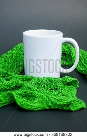 White Coffee Mug Nestled In Green Lace Scarf On A Dark Background With Copy Space For Text Or Graphi