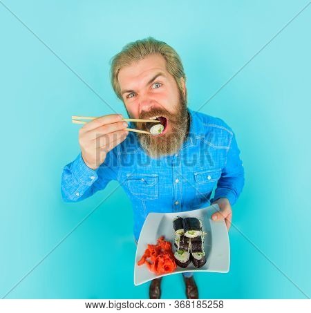 Man Eating Sushi. Sushi. Man With Sushi On Chopstick. Japan. Sushi Delivery. Japanese Food. Pickled 