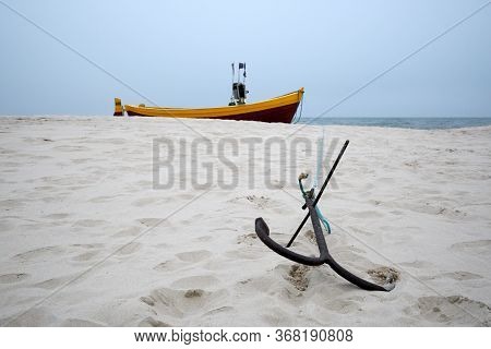 Anchor From A Fishing Boat On A Sandy Beach.