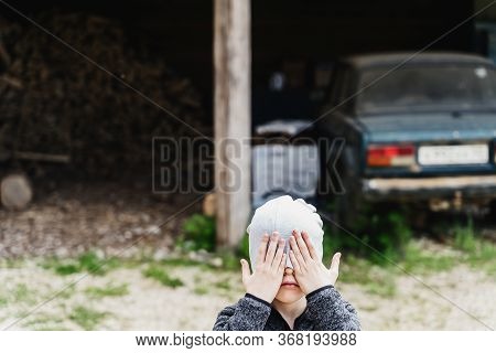 Boy Closed His Eyes With His Hands Against The Background Of A Rustic Canopy