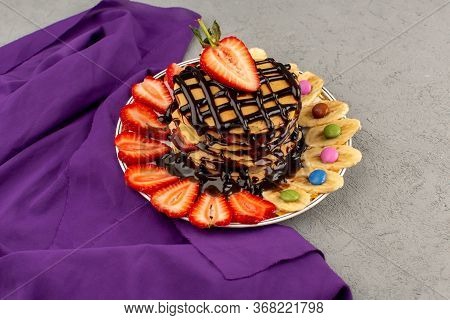 A Top View Pancakes With Chocolate Red Sliced Strawberries And Bananas Inside White Plate On The Gre