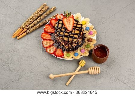 A Top View Yummy Pancakes Choco Pancakes With Red Sliced Straweberries And Bananas Inside White Plat