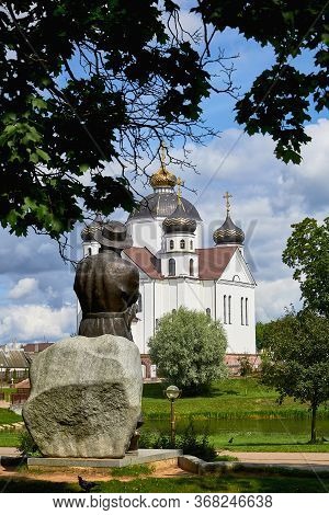 Belarus, Smorgon, August 2019. The Monument To The Belarusian Poet Bogushevich Faces The White Churc