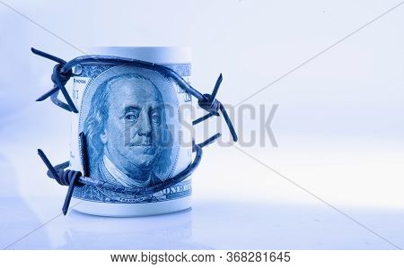 Economic Warfare, Sanctions And Embargo Busting Concept. Us Dollar Wrapped In Barbed Wire.