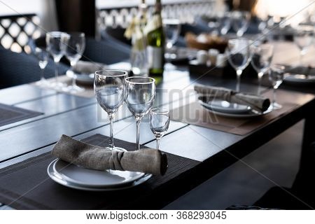 Served Wooden Table With Three Empty Wineglasses