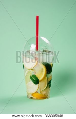 Lemonade To Go Cup With Mint, Lime And Lemon On Lightgreen Background, Isolated