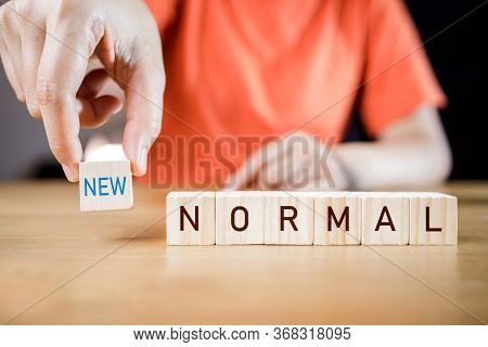 Woman\'s Hand Putting Wooden Cubes With Concept New Or Next Normal. New Normal Life After Covid Cris
