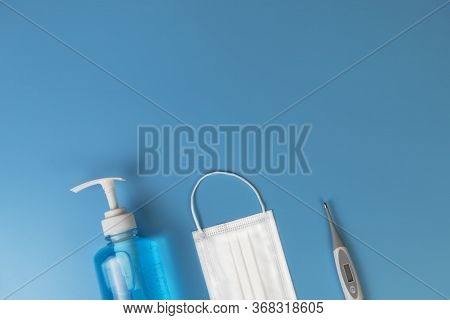Hygienic Masks Digital Thermometer , Alcohol Spray On Blue Baxkground. Medical Face Mask, Alcohol Sa
