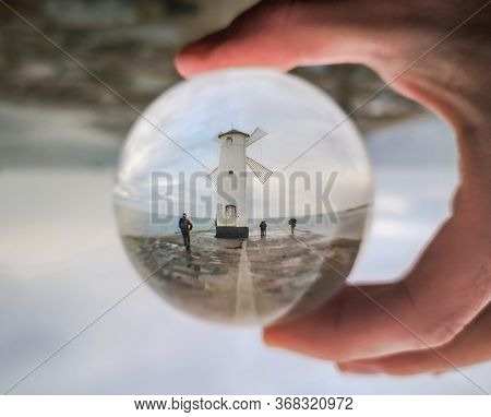 White Windmill At End Of Coast Full Of Puddles Near Baltic Sea In Swinoujscie In Reflection Of Cryst