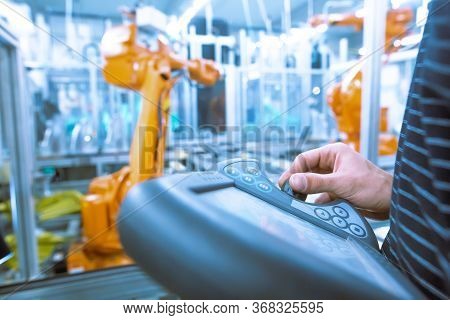 Young Man Programming Industrial Automatic Robot In The Automotive Industry, Industrial Concept