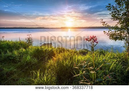 Valday. Lake Valdai In The Early Summer Morning With A Beautiful Golden Sky And Grass In The Dew On 