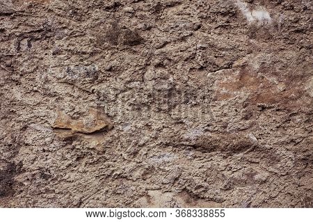 Dry, Barren Land. Hard Texture Of The Soil With Brown Stones And Sand. Background Of The Earth Witho