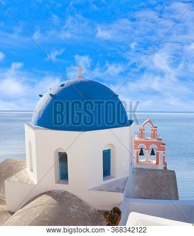 Blue Domed Anastasi Greek Church And Belfry Against Volcano Caldera In Oia Town On Santorini Island,