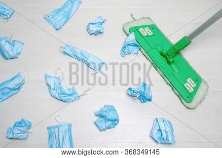 Cleaning At Hospital, Public Places. Mop And Used Medical Masks On The Floor. Utilization Of Protect