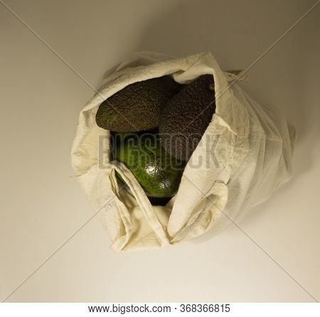 Different Varieties Of Avocado Ripen In A Light Canvas Bag On A White Background. Top View