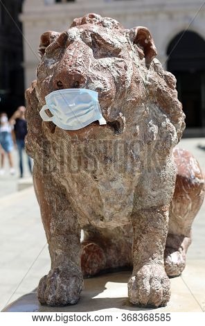 Funny Statue Of Lion In Venice In Surgical Mask During Lockdown By Corona Virus In Italy