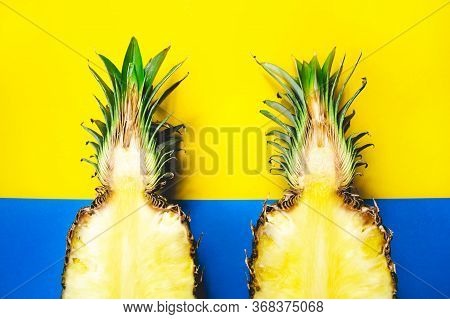 Modern Flat Lay Pattern With Two Pineapple Fruits Half Creative Concept On Blue And Yellow Backgroun