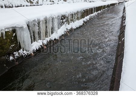 Urban Stream In Winter. Icicles On Concrete River Banks. The Lybid River (kyiv, Ukraine) In The Snow