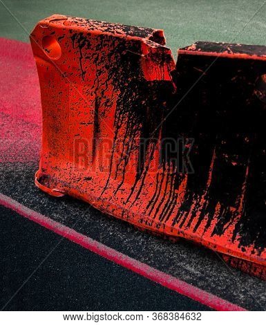 Orange Dirty Safety Barrier On The Road. Red Painted Asphalt. Red Road Surface Marking.