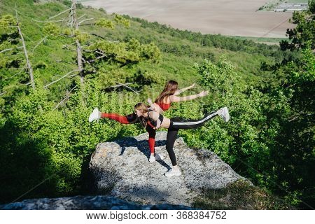Girls Play Sports In The Mountains. Sport On The Pro-prod. Fitness In The Woods. Yoga In Nature.