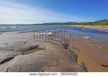 Polished Rocks And Sand On A Remote Shore Of Lake Superior In Neys Provincial Park In Ontario
