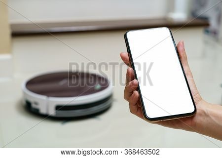 Hand Holding Smartphone With Blanking Screen For Control Robotic Vacuum Cleaner . Smart Life Technol